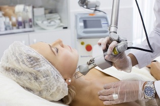 Cosmetologist rejuvenates skin with laser. 